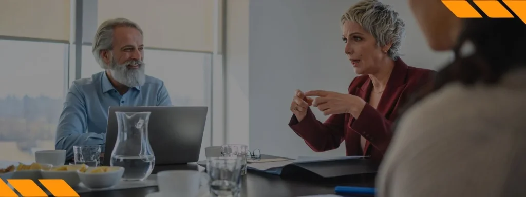 Profissionais conversando em uma reunião, aplicando comunicação assertiva, técnicas de oratória e retórica no ambiente de trabalho.