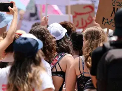 Várias pessoas com cartazes em passeata lutando pelos direitos humanos.