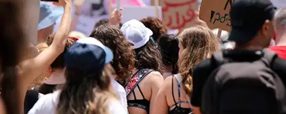 Várias pessoas com cartazes em passeata lutando pelos direitos humanos.