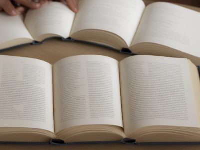 Mãos tocando e explorando pontos em relevo do sistema braille, simbolizando a leitura e a inclusão de pessoas com deficiência visual.