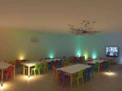 Crianças ouvindo e interagindo em uma sessão de contação de histórias na educação infantil, com fantoches e recursos visuais.