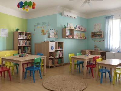 Crianças ouvindo uma contadora de histórias com fantoches em uma sala de aula da educação infantil, aprendendo e se divertindo.