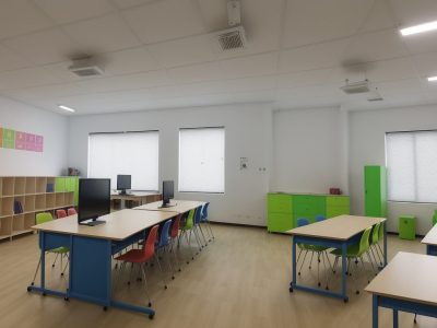 Alunos engajados em atividades de aprendizagem criativa e cultura maker em uma sala de aula inovadora.