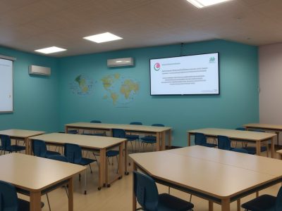 Alunos engajados em sala de aula com professor mediando para promover disciplina escolar.