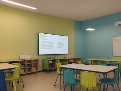 Professor em sala de aula, aplicando metodologias ativas e usando tecnologia, com foco no curso online de docência e práticas educativas.