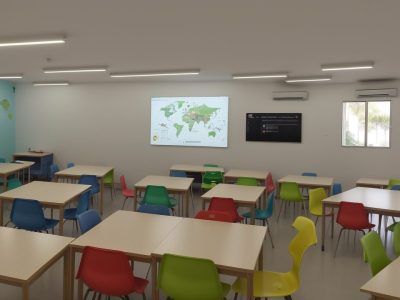 Imagem ilustrando a educação empreendedora em ação em uma sala de aula moderna, com estudantes engajados e tecnologia.