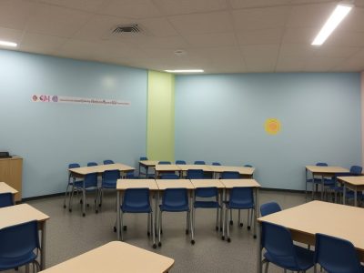 Professor e alunos em sala de aula inclusiva, com foco em adaptações curriculares e atividades de educação especial