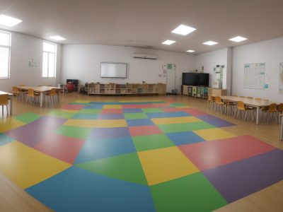 Alunos com deficiência física em sala de aula inclusiva, interagindo com educadores e recursos pedagógicos adaptados.