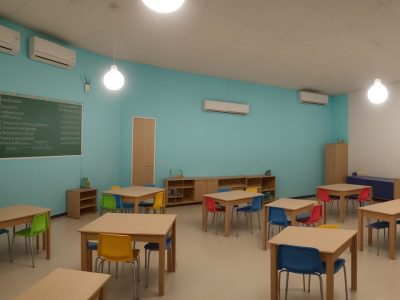 Imagem mostrando uma sala de aula inclusiva com alunos e educadores interagindo, focando em educação especial e deficiência física.