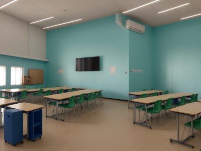 Cena de uma sala de aula onde alunos adultos interagem e aprendem na Educação de Jovens e Adultos.