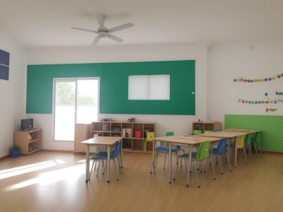 Crianças aprendendo matemática de forma interativa e divertida em uma sala de aula, com recursos didáticos e professores motivados.