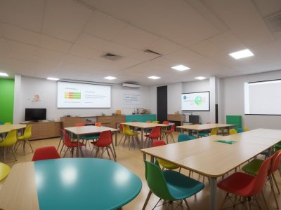 Sala de aula com alunos interagindo com jogos e projetos para o ensino da matemática, demonstrando engajamento e aprendizado.