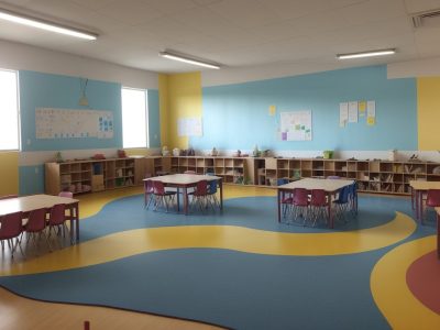 Professora ensinando artes em sala de aula, mostrando atividades artísticas para crianças e incentivando a criatividade.