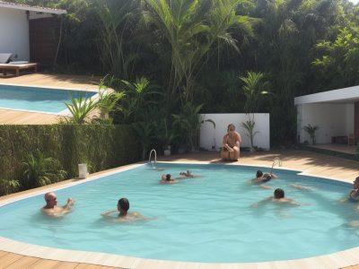 Aula de hidroginástica com idosos se exercitando na piscina, com foco nos benefícios para a saúde e bem-estar.