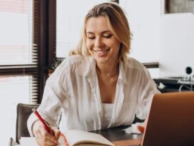 IMAGEM-TRIO-mulher-trabalhando-em-casa-no-laptop-escrevendo-em-uma-agenda