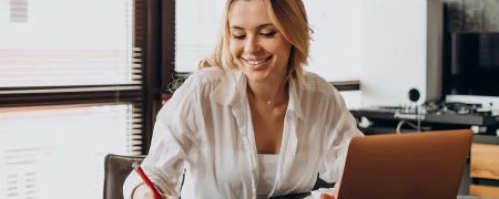 IMAGEM-TRIO-mulher-trabalhando-em-casa-no-laptop-escrevendo-em-uma-agenda