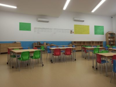 Crianças com autismo participando ativamente em sala de aula inclusiva, com foco em currículo adaptado e apoio educacional
