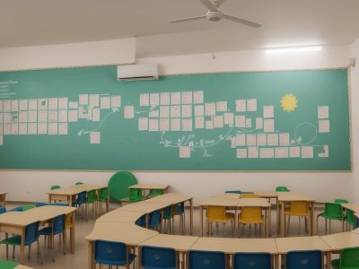 Professora interagindo com alunos em sala de aula inclusiva, com foco em curso sobre autismo e estratégias de ensino para autismo.