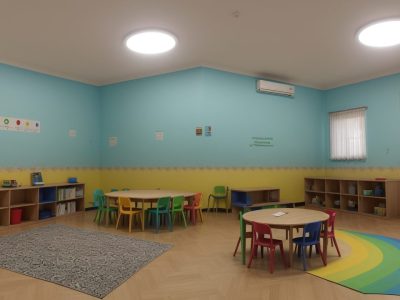 Crianças com síndrome de Down interagindo em sala de aula inclusiva, com atividades e apoio educacional.