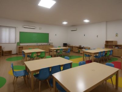 Crianças em sala de aula inclusiva aprendendo com estratégias de ensino adaptadas para alunos com deficiência intelectual.