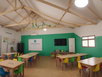 Crianças em sala de aula envolvidas em atividades lúdicas e colaborativas de aprendizado.