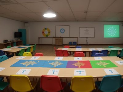 Professora e alunos colaborando em atividades de intervenção psicopedagógica na escola, utilizando jogos e materiais didáticos.