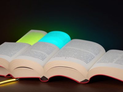 Imagem de um livro aberto com setas indicando velocidade e um cérebro, simbolizando leitura dinâmica e técnicas de leitura rápida.