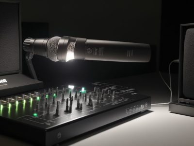 Um microfone profissional em primeiro plano, simbolizando o curso de locução e sonoplastia, com fundo desfocado de um estúdio de gravação, representando a oportunidade de carreira.