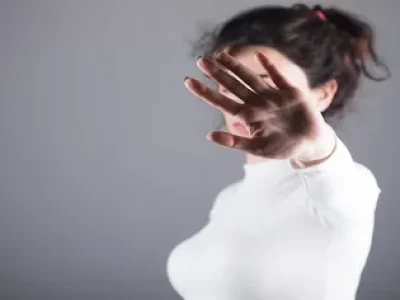 Mulher-com-a-mao-levantada-tampando-o-rosto-2