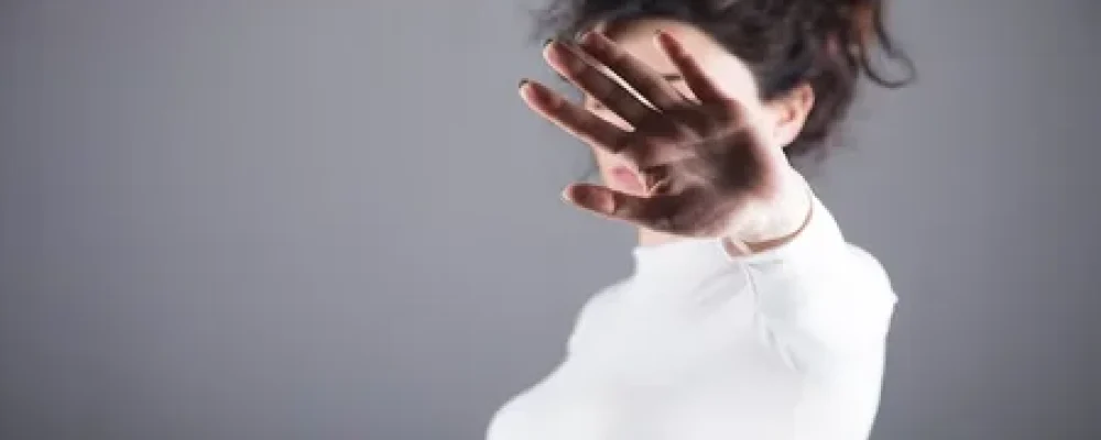 Mulher-com-a-mao-levantada-tampando-o-rosto-2