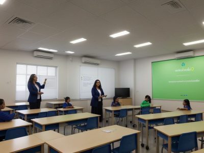 Professora explicando o novo acordo ortográfico em sala de aula, com exemplos visuais e estudantes atentos.