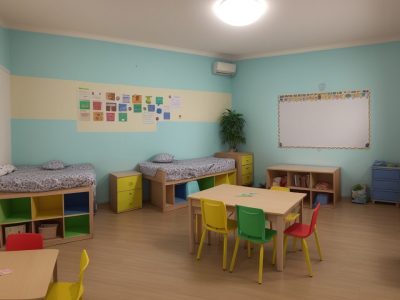 Crianças e professoras em sala de aula, com foco em relatório descritivo para educação infantil, incentivando o acompanhamento escolar.