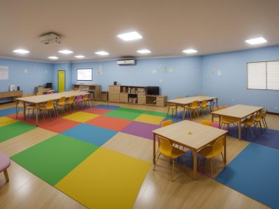 Crianças e educadores em sala de aula discutindo temas transversais e projetos interdisciplinares, promovendo aprendizado integrado.