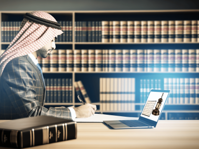 Advogado concentrado redigindo documento jurídico em escritório com livros de direito e laptop, iluminado suavemente.