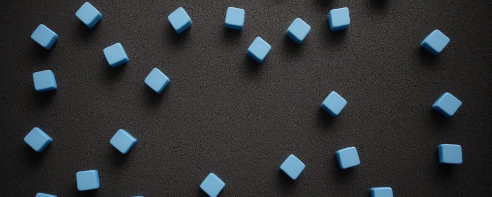 Advogado em escritório moderno analisando o código de processo penal enquanto colega demonstra evolução de casos em computador.