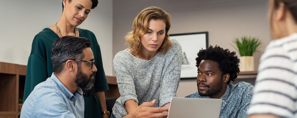 Assédio moral no trabalho: o que fazer? Imagem de um ambiente de trabalho com colaboradores interagindo de forma respeitosa e harmônica, representando um local livre de assédio moral.