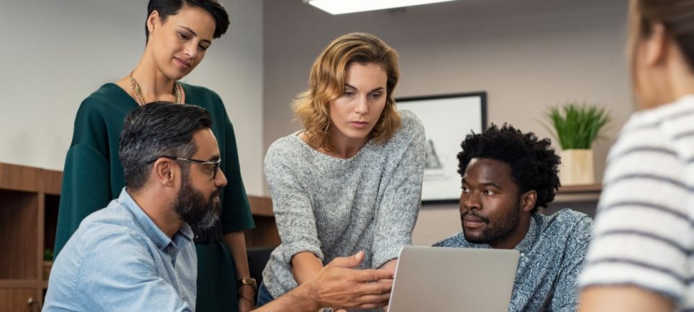 Assédio moral no trabalho: o que fazer? Imagem de um ambiente de trabalho com colaboradores interagindo de forma respeitosa e harmônica, representando um local livre de assédio moral.