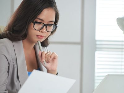 Profissional estudando curso de inteligência emocional e lendo livros para desenvolver competências emocionais no trabalho.
