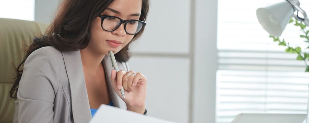 Profissional estudando curso de inteligência emocional e lendo livros para desenvolver competências emocionais no trabalho.