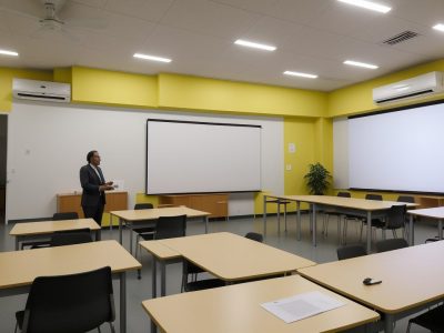 Grupo de estudantes discutindo conceitos de direito penal em uma sala de aula moderna e iluminada.