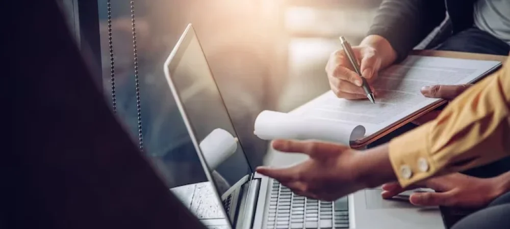 duas-pessoas-discutindo-sobre-documentos-no-notebook-1 duas-pessoas-discutindo-sobre-documentos-no-notebook-1