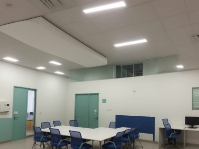 Equipe diversificada em reunião sobre segurança do trabalho com técnico explicando planos em um ambiente moderno.