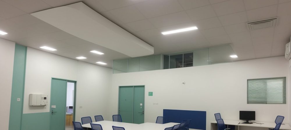 Equipe diversificada em reunião sobre segurança do trabalho com técnico explicando planos em um ambiente moderno.