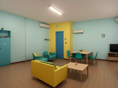 Estudantes de diferentes etnias discutindo sobre direitos humanos em sala de aula, com cartazes coloridos.