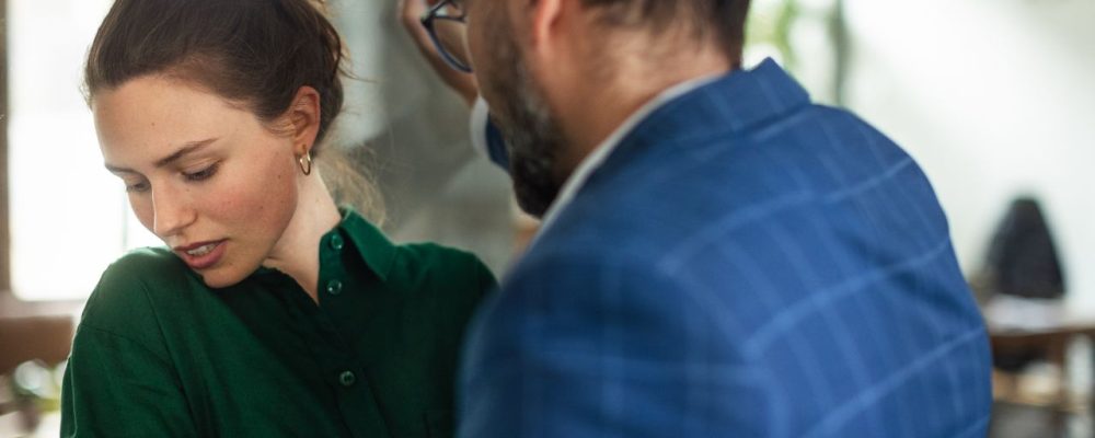 O que é assédio moral? Homem, supostamente um chefe, humilhando uma funcionária