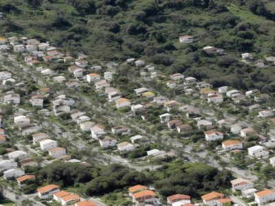Cidade moderna com moradores participando de campanhas de reciclagem, destacando a gestão de resíduos sólidos em áreas urbanas.