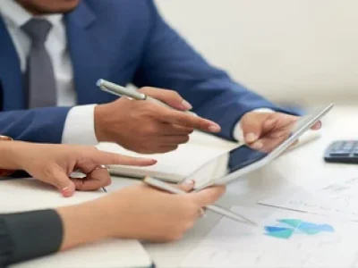 pessoas-de-negocios-irreconheciveis-sentado-na-reuniao-com-graficos-olhando-e-apontando-para-tablet-1