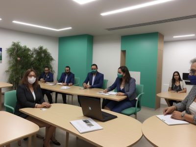 Servidores públicos em reunião discutindo psicologia social com anotações e gráficos, promovendo interação.