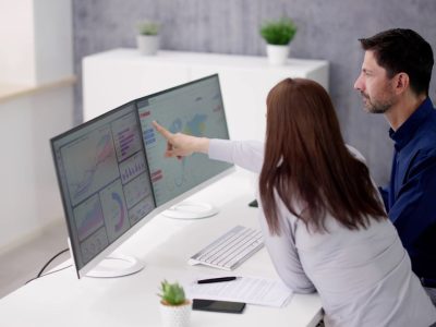 Ilustração de profissionais analisando dados em telas digitais, representando tendências tecnológicas aplicadas à gestão pública.